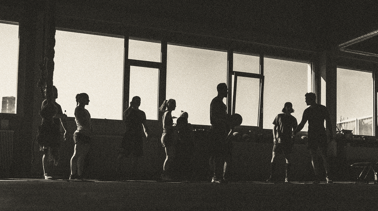 People working out in a modern fitness gym with large windows